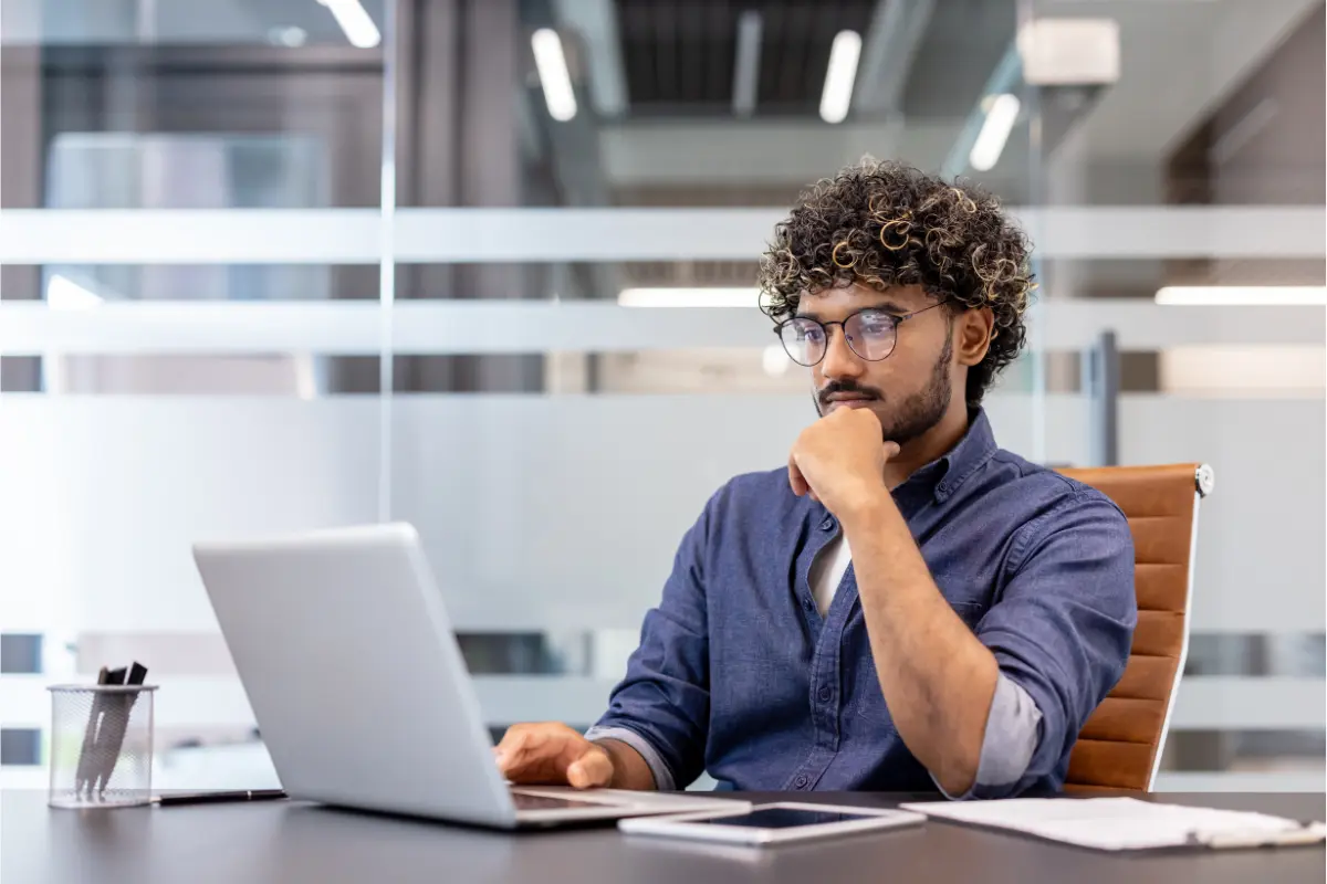 Entrepreneur reviewing business and tax information on a laptop while comparing EIN and SSN requirements for a small business