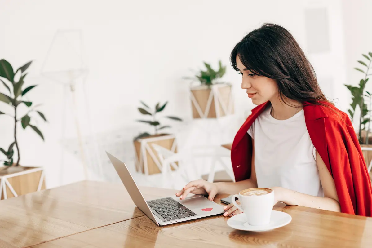 Business owner reviewing an LLC operating agreement while working on a laptop at a home office desk