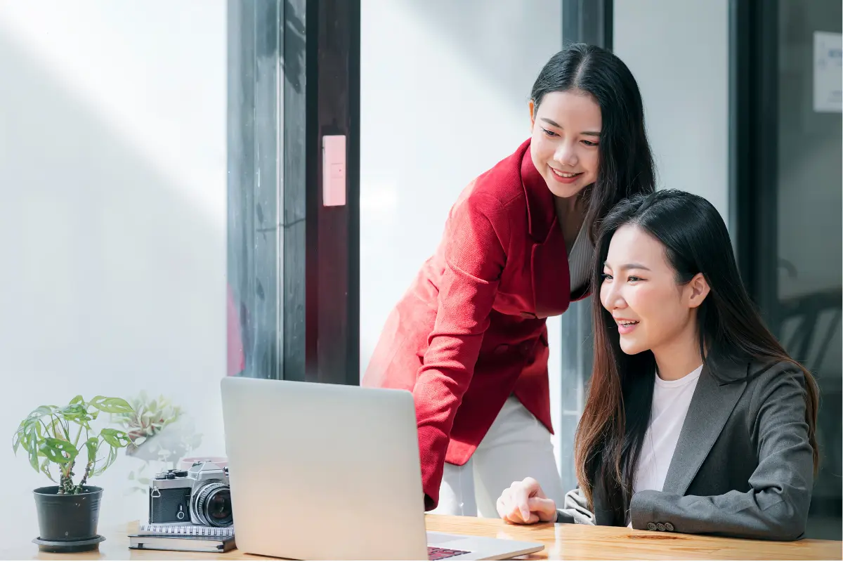 Two business partners collaborating on a laptop to form a multi-member LLC and review their operating agreement and ownership structure