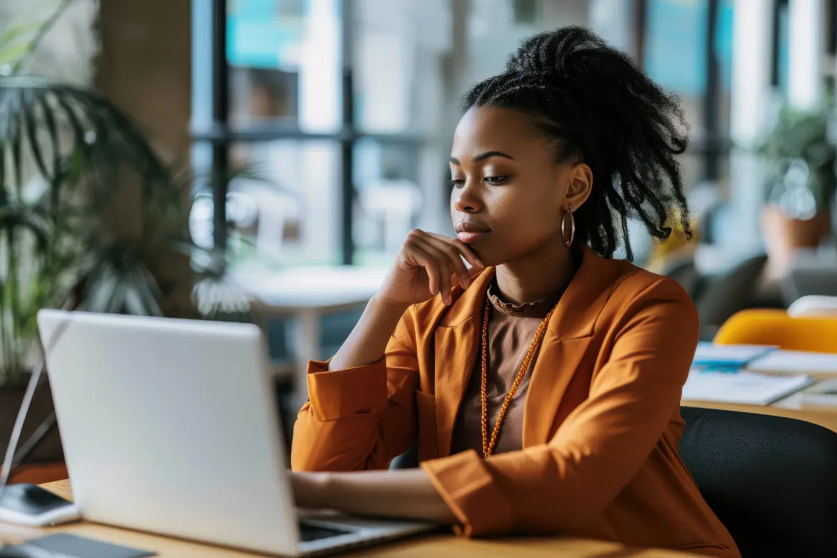 Businesswoman researching registered agent requirements on a laptop in modern office setting